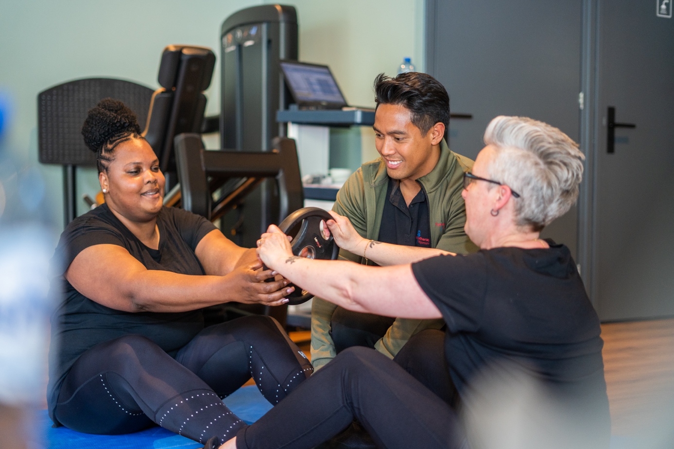 Fysiotherapeut traint met twee patiënten in Spijkenisse